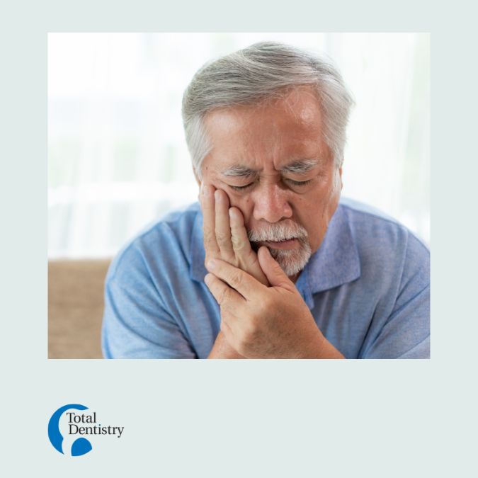Man holding the side of his face grimacing in pain from a toothache